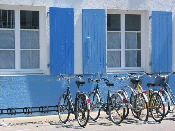 Vélos devant une maison aux volets bleus